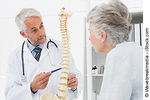 Arzt erklärt Frau am Skelett die Osteoporose